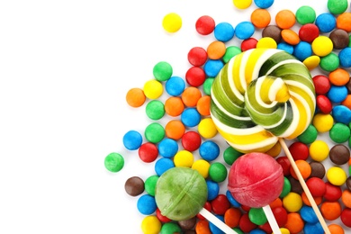 Lollipops and colorful candies on white background, top view