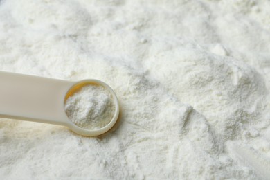 Photo of Powdered infant formula and scoop, closeup with space for text. Baby milk