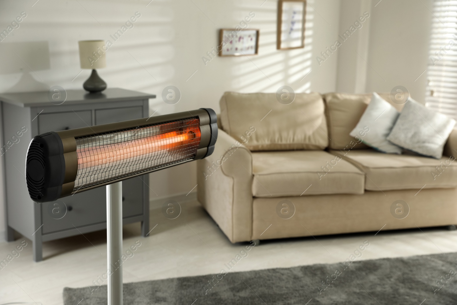 Photo of Modern electric infrared heater in living room, closeup