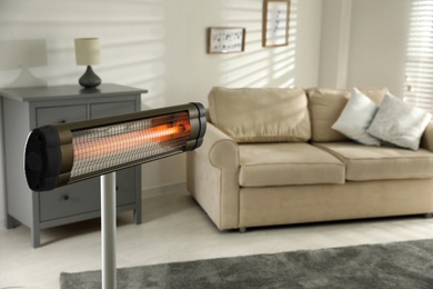 Photo of Modern electric infrared heater in living room, closeup