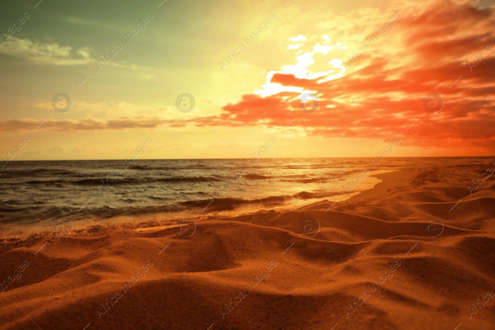 Image of Picturesque view of beautiful orange sky with clouds over beach and sea at sunset