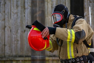 Photo of Firefighter in uniform wearing helmet and mask outdoors