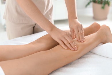 Photo of Woman receiving leg massage in wellness center, closeup