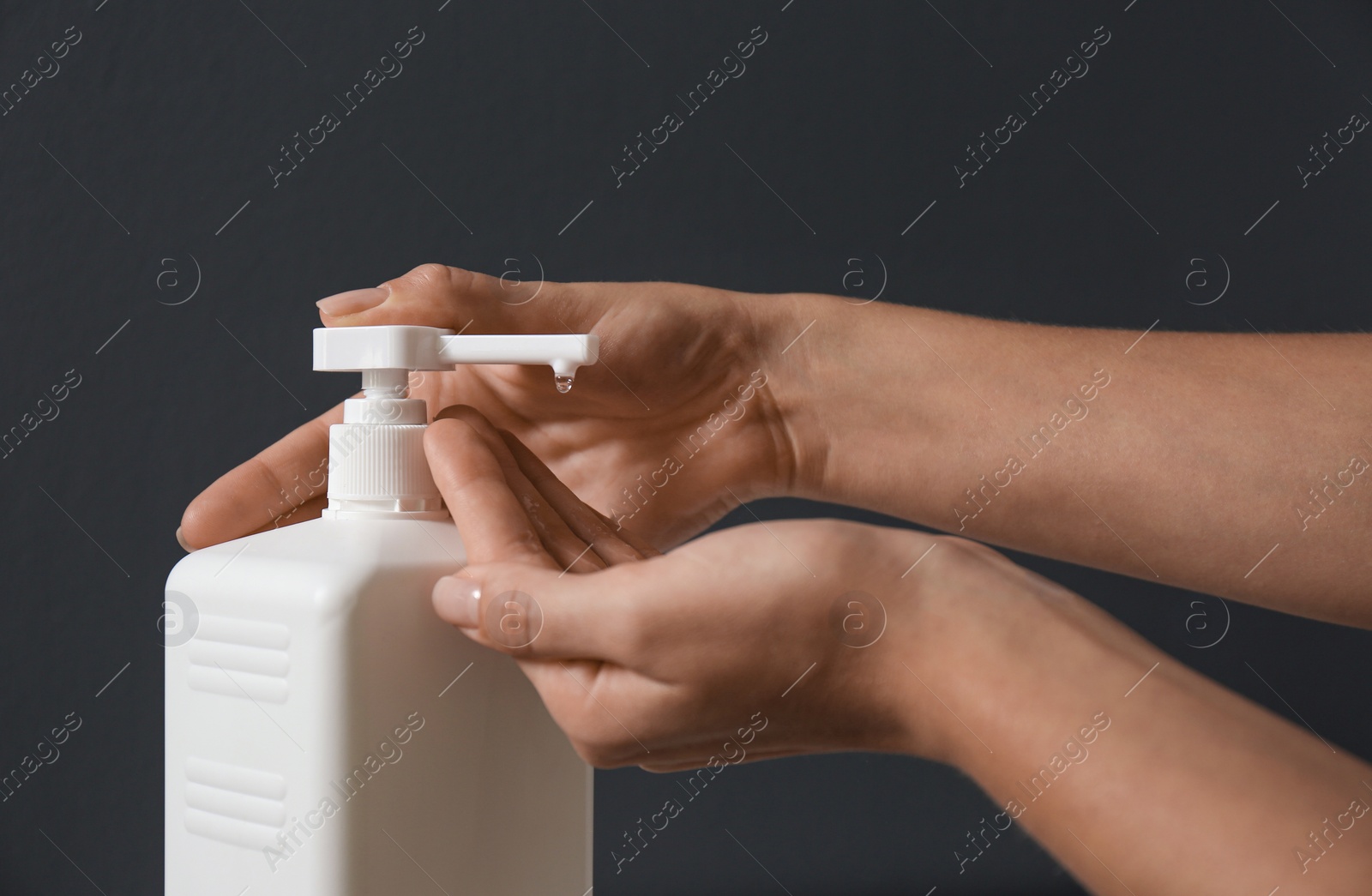 Photo of Woman applying hand sanitizer on grey background, closeup. Personal hygiene during COVID-19 pandemic