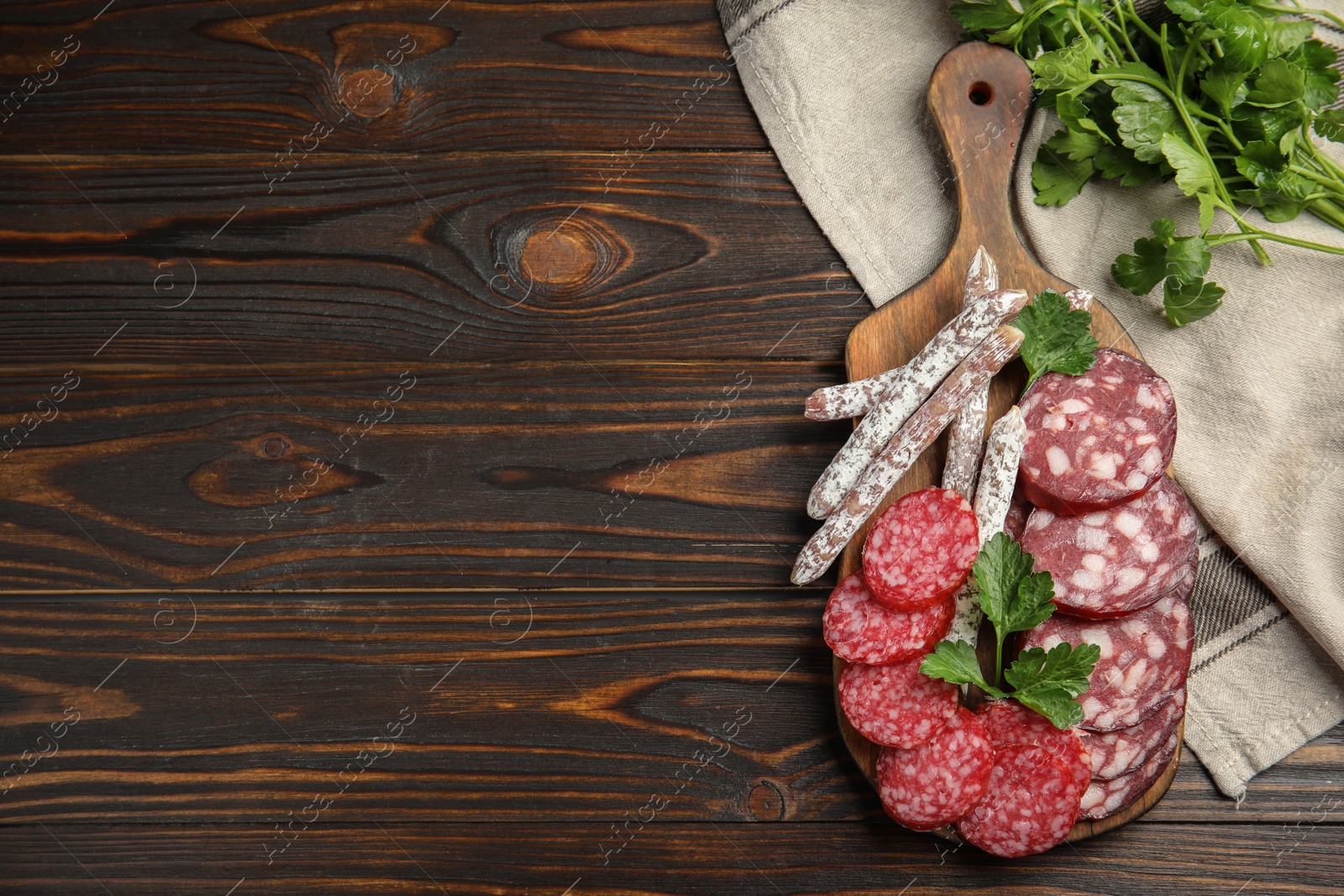 Photo of Different types of sausages served on wooden table, flat lay. Space for text