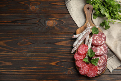 Photo of Different types of sausages served on wooden table, flat lay. Space for text