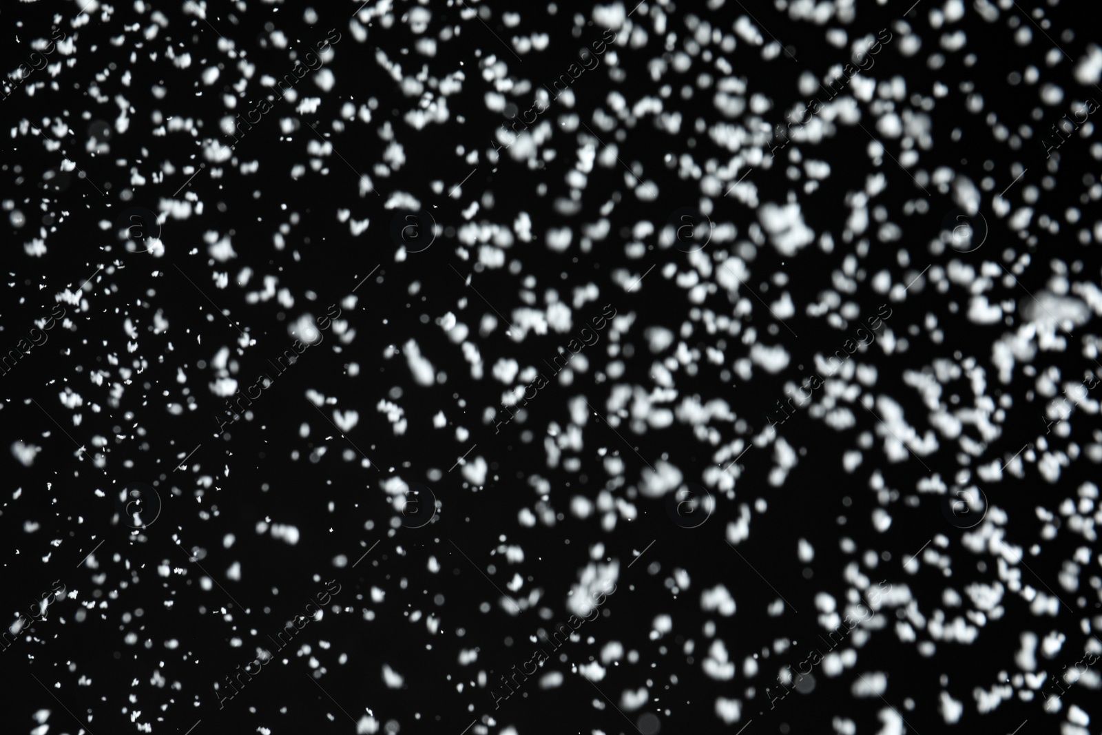 Photo of White snow falling down on black background