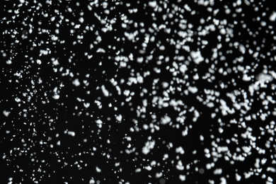 Photo of White snow falling down on black background