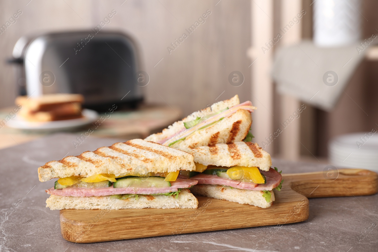 Photo of Tasty sandwich with ham on marble table indoors