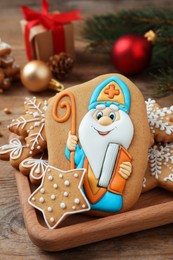 Photo of Tasty gingerbread cookies and festive decor on wooden table. St. Nicholas Day celebration