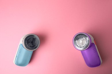 Photo of Modern fabric shavers on pink background, flat lay