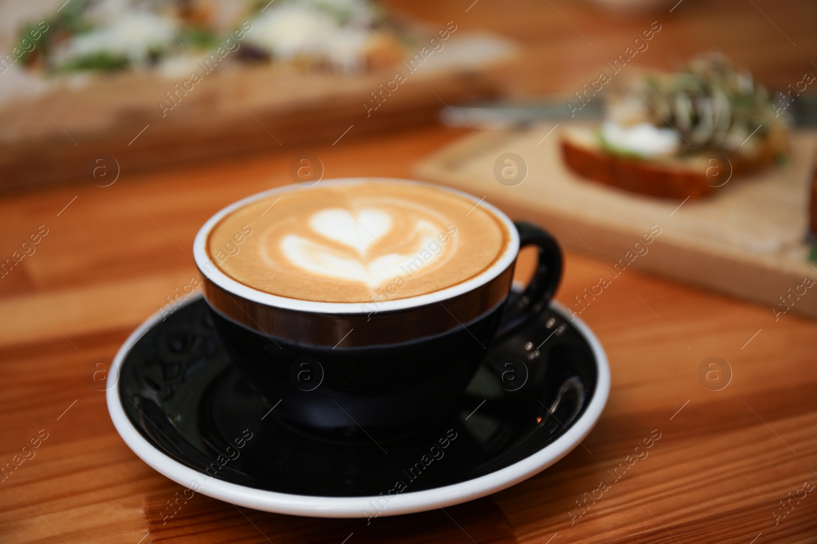 Photo of Cup of delicious coffee on wooden table