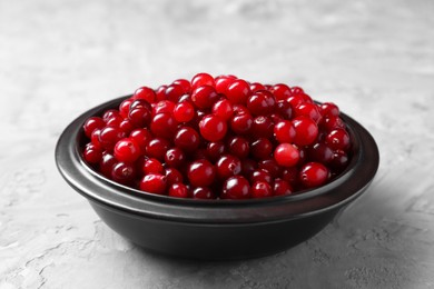 Photo of Fresh ripe cranberries in bowl on grey table