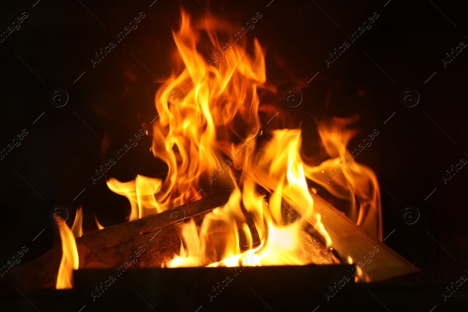 Photo of Fireplace with burning wood, closeup view. Winter vacation