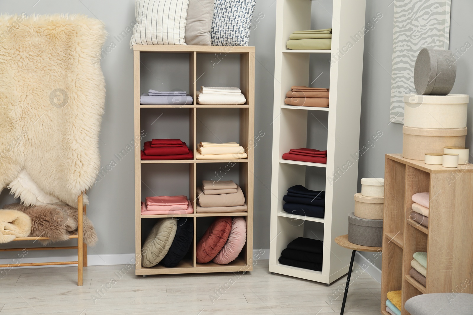 Photo of Different colorful bed linens and decorative boxes on display in home textiles store