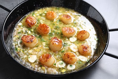 Fried scallops with sauce in dish on grey table, closeup