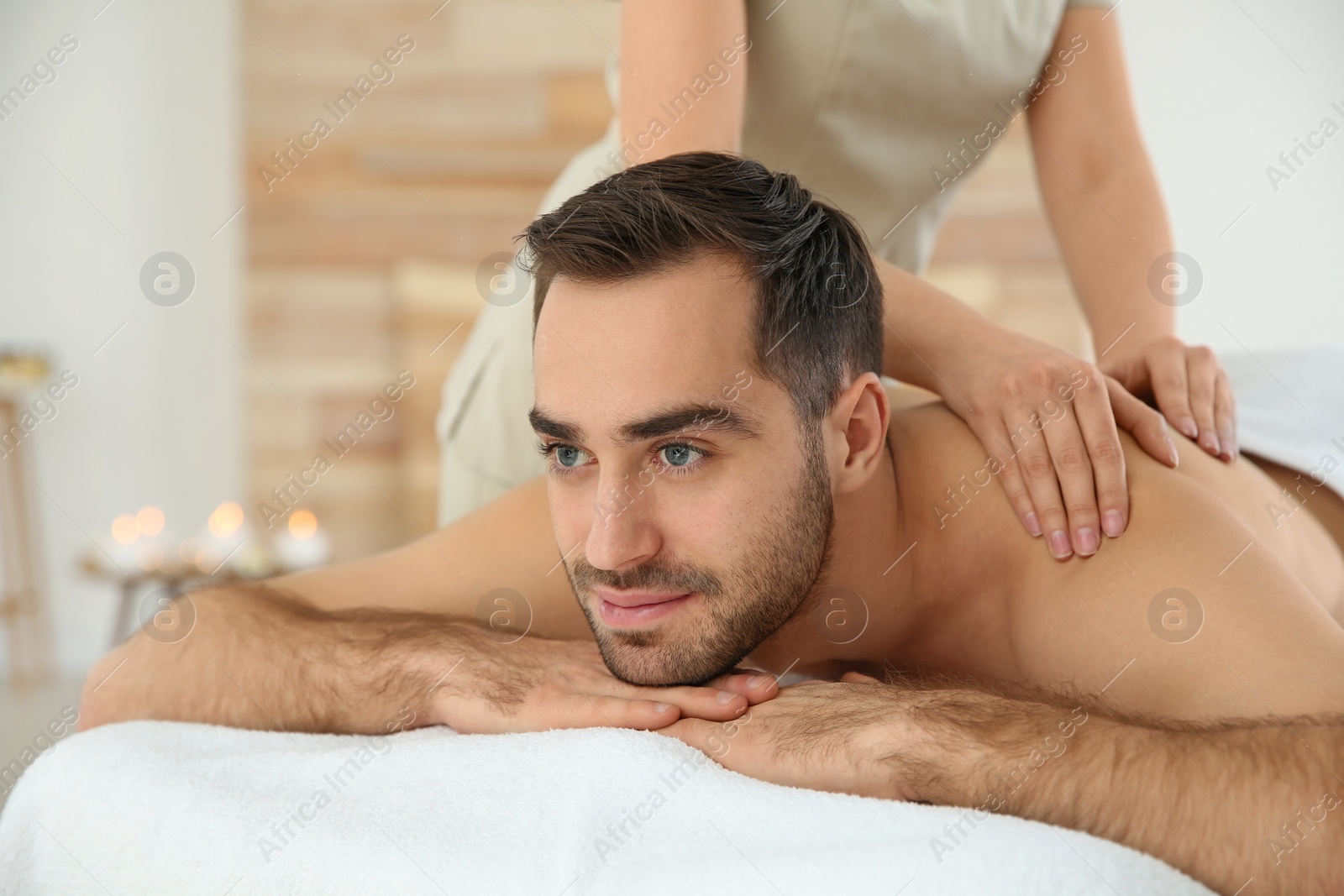 Photo of Handsome man receiving back massage in spa salon