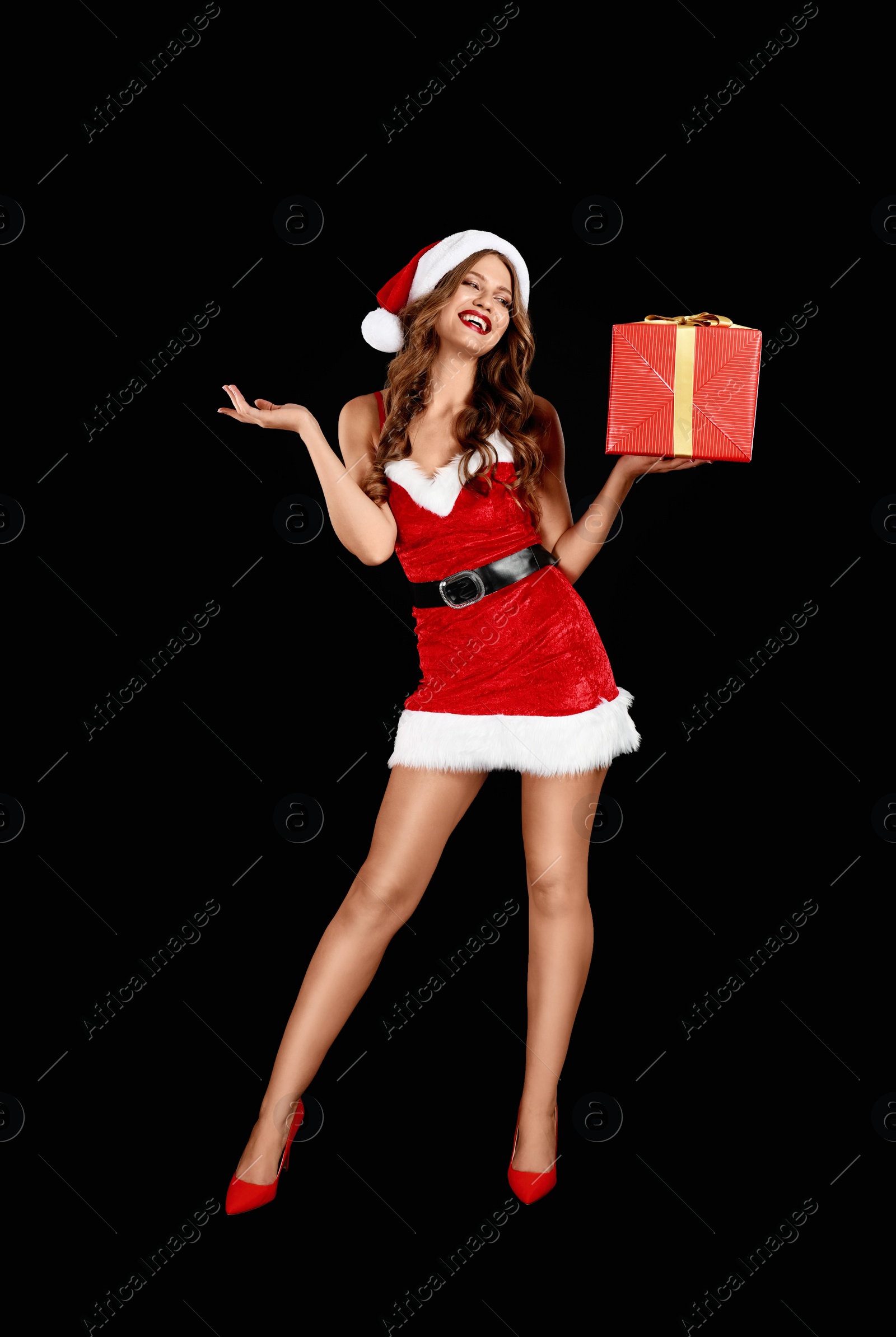 Photo of Beautiful Santa girl with Christmas gift on black background