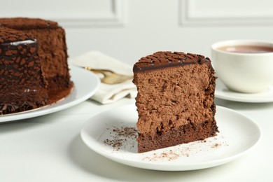 Piece of delicious chocolate truffle cake on white table