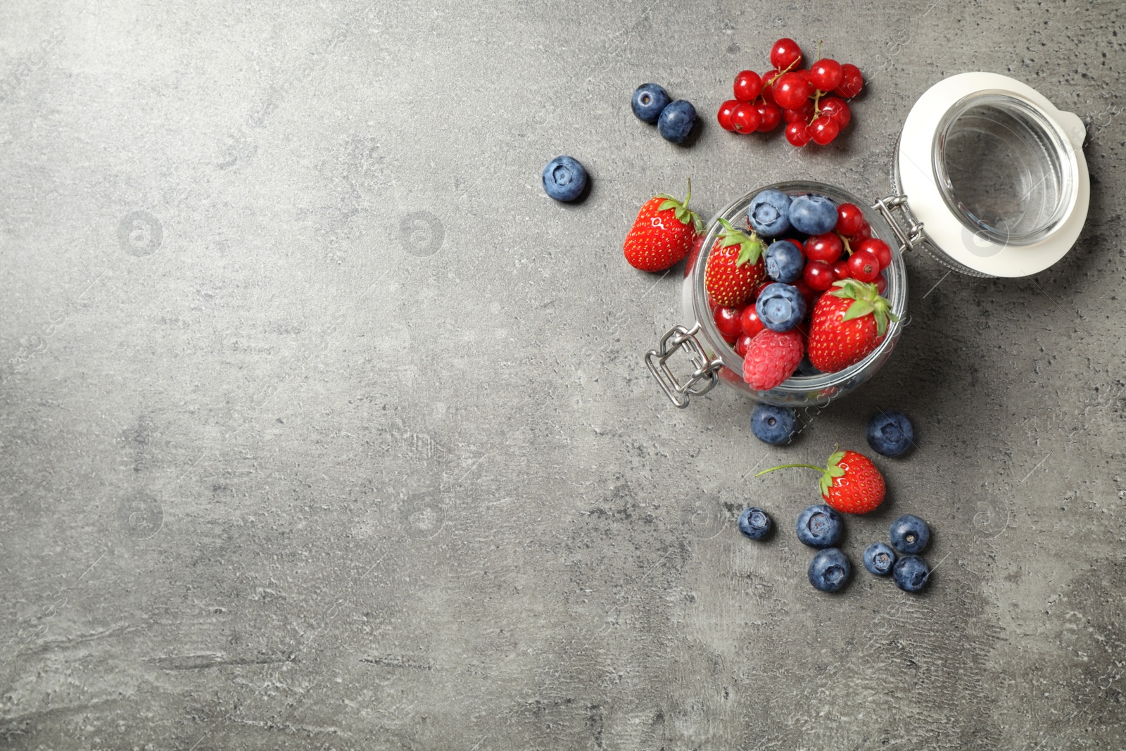 Photo of Mix of ripe berries on grey table, flat lay. Space for text