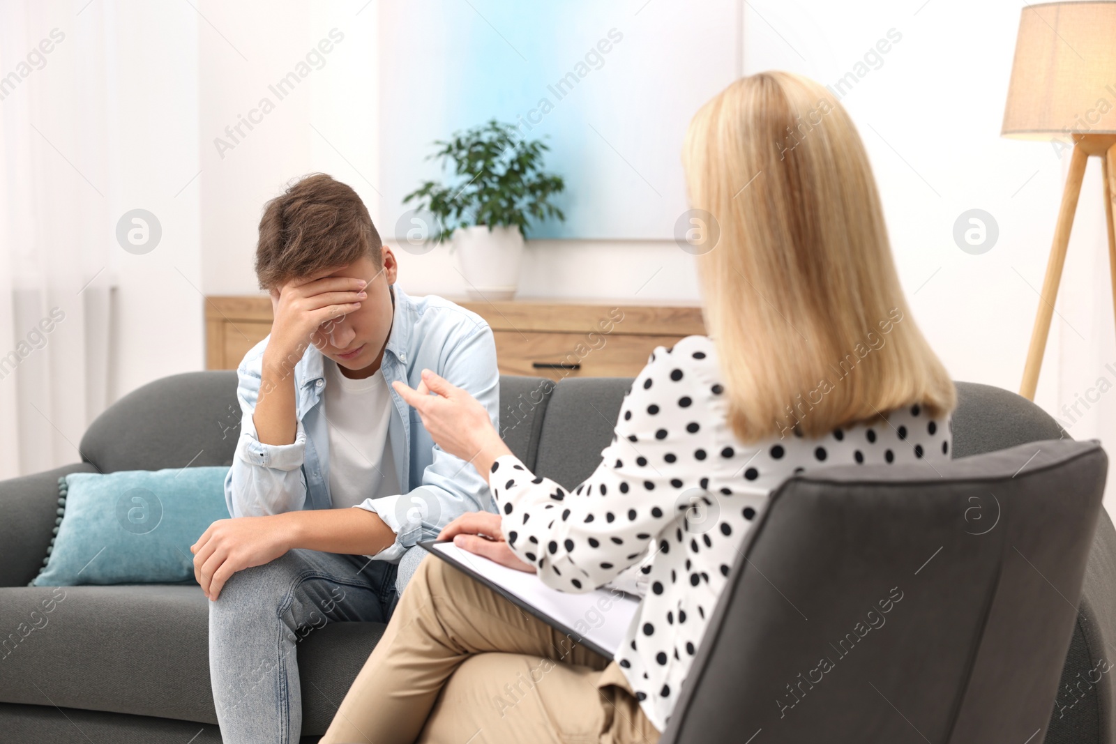 Photo of Psychologist working with teenage boy in office