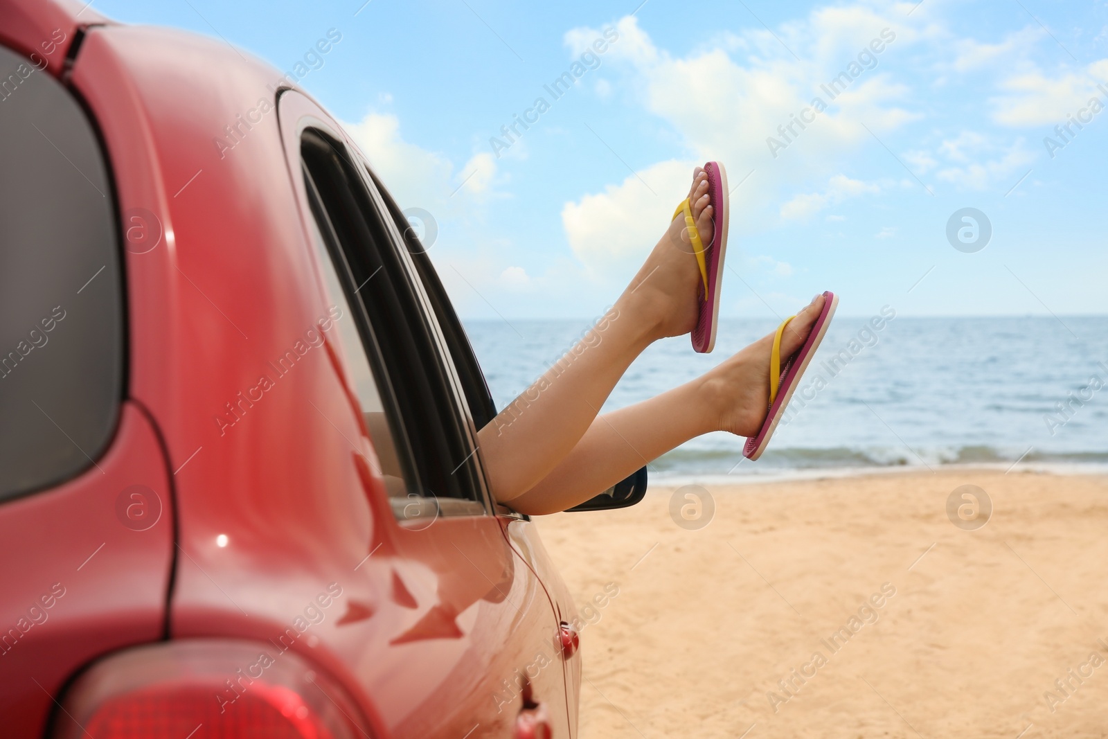 Photo of Woman showing legs from car, closeup. Summer vacation trip