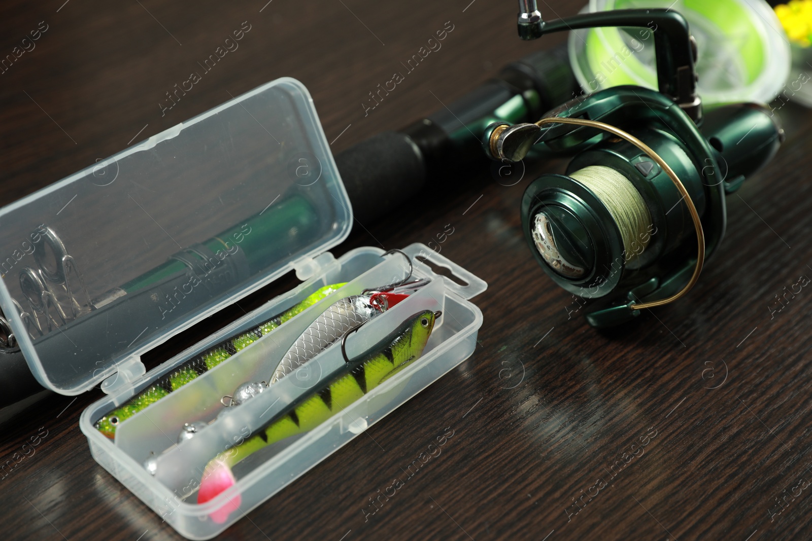 Photo of Fishing tackle on dark wooden background, closeup