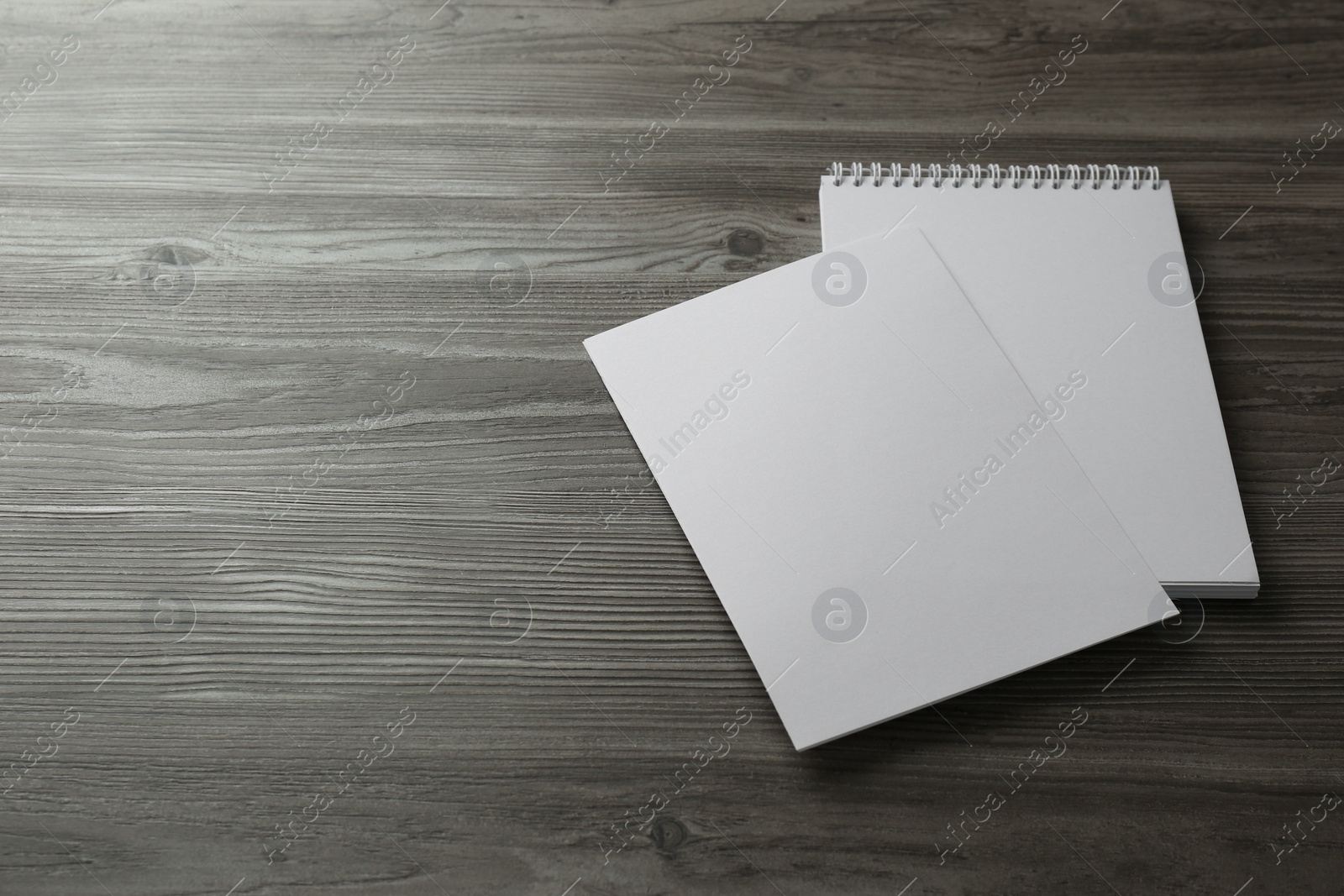 Photo of Sheet of paper and blank brochure on wooden table. Mockup for design