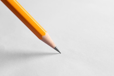 Photo of One sharp graphite pencil on white background, closeup. Space for text