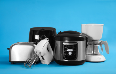 Photo of Set of different household appliances on light blue background