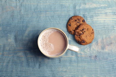 Flat lay composition with hot cocoa drink and cookies on wooden background