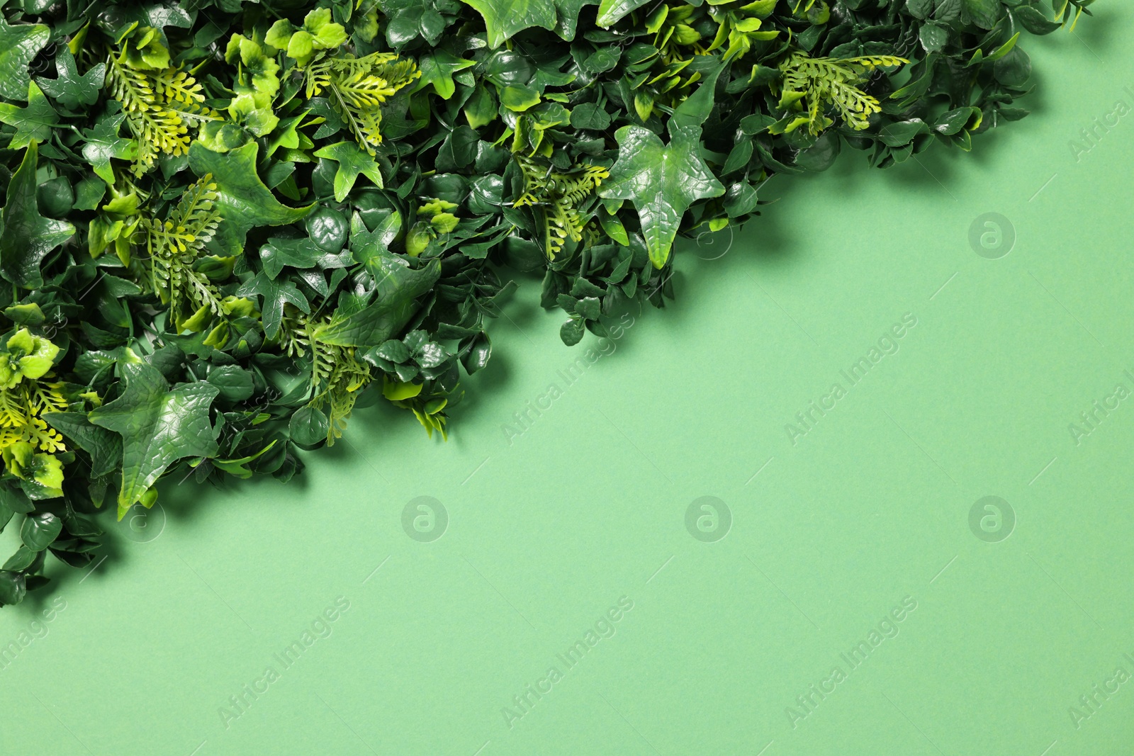 Photo of Green artificial plants on color background, top view. Space for text