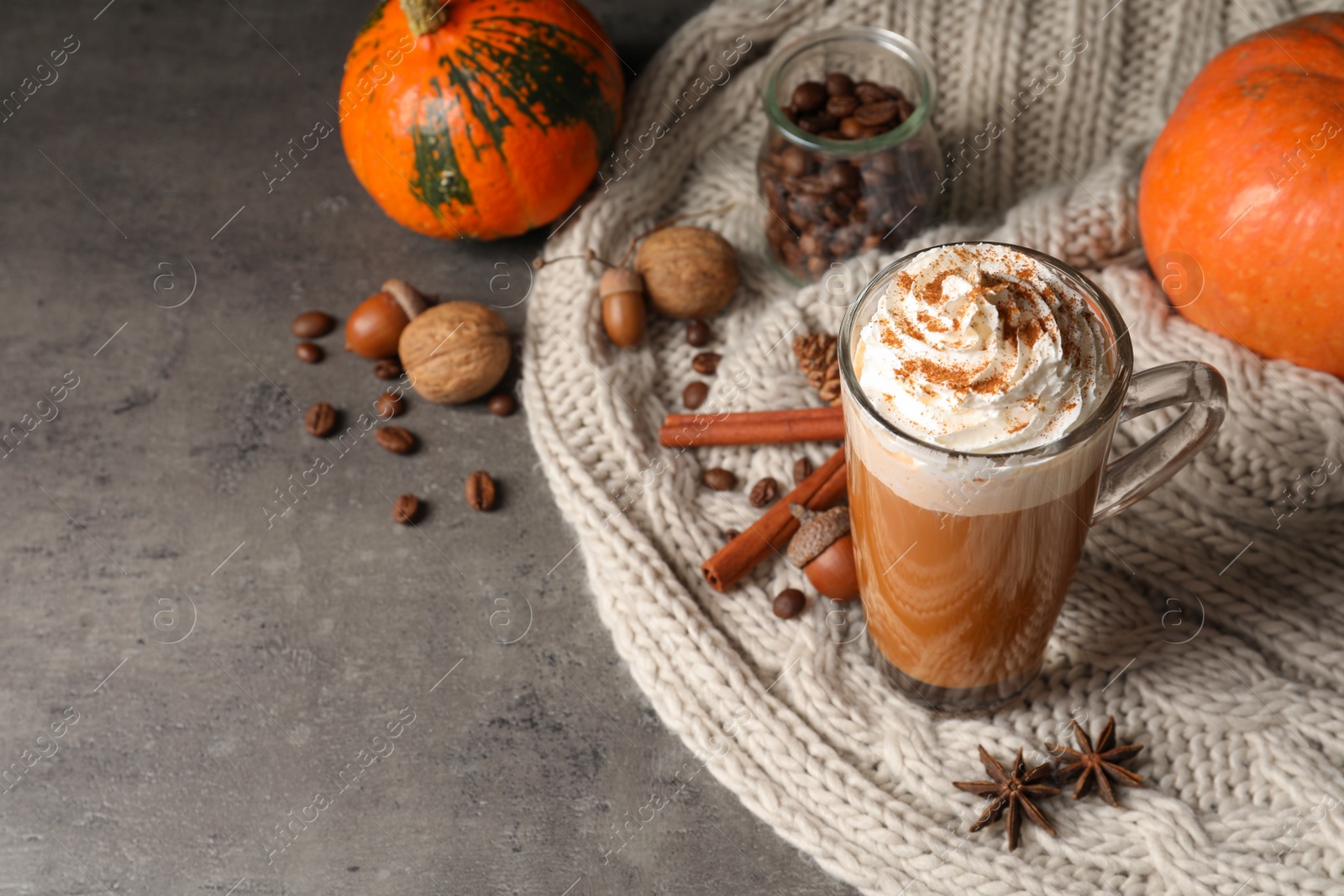 Photo of Glass cup with tasty pumpkin spice latte and space for text on table