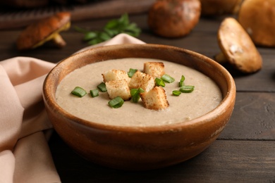 Photo of Bowl of fresh homemade mushroom soup on wooden table