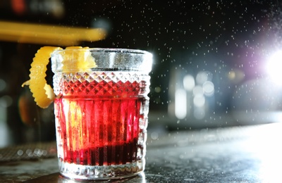 Photo of Fresh alcoholic Red Russian cocktail on bar counter. Space for text