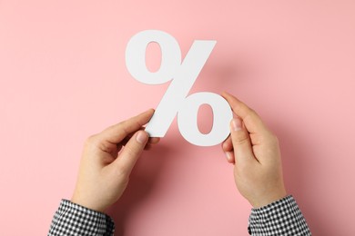 Photo of Man holding percent sign on pink background, top view