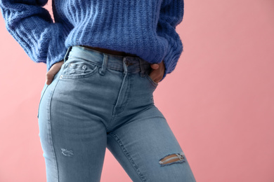 Woman wearing jeans on pink background, closeup