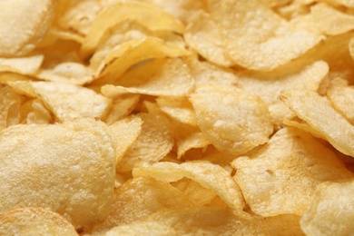 Photo of Pile of crispy potato chips as background, closeup