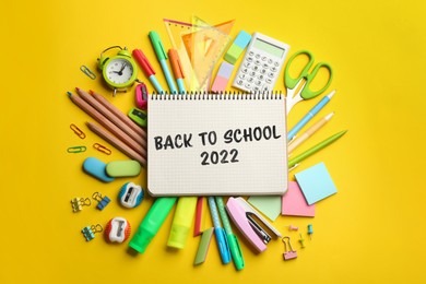 Back to school 2022. Different stationery on yellow background, flat lay