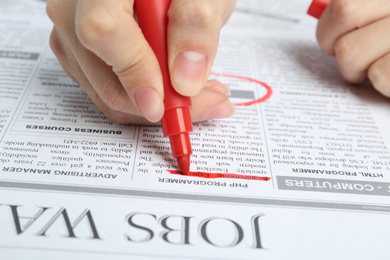 Photo of Woman marking advertisement in newspaper, closeup. Job search concept