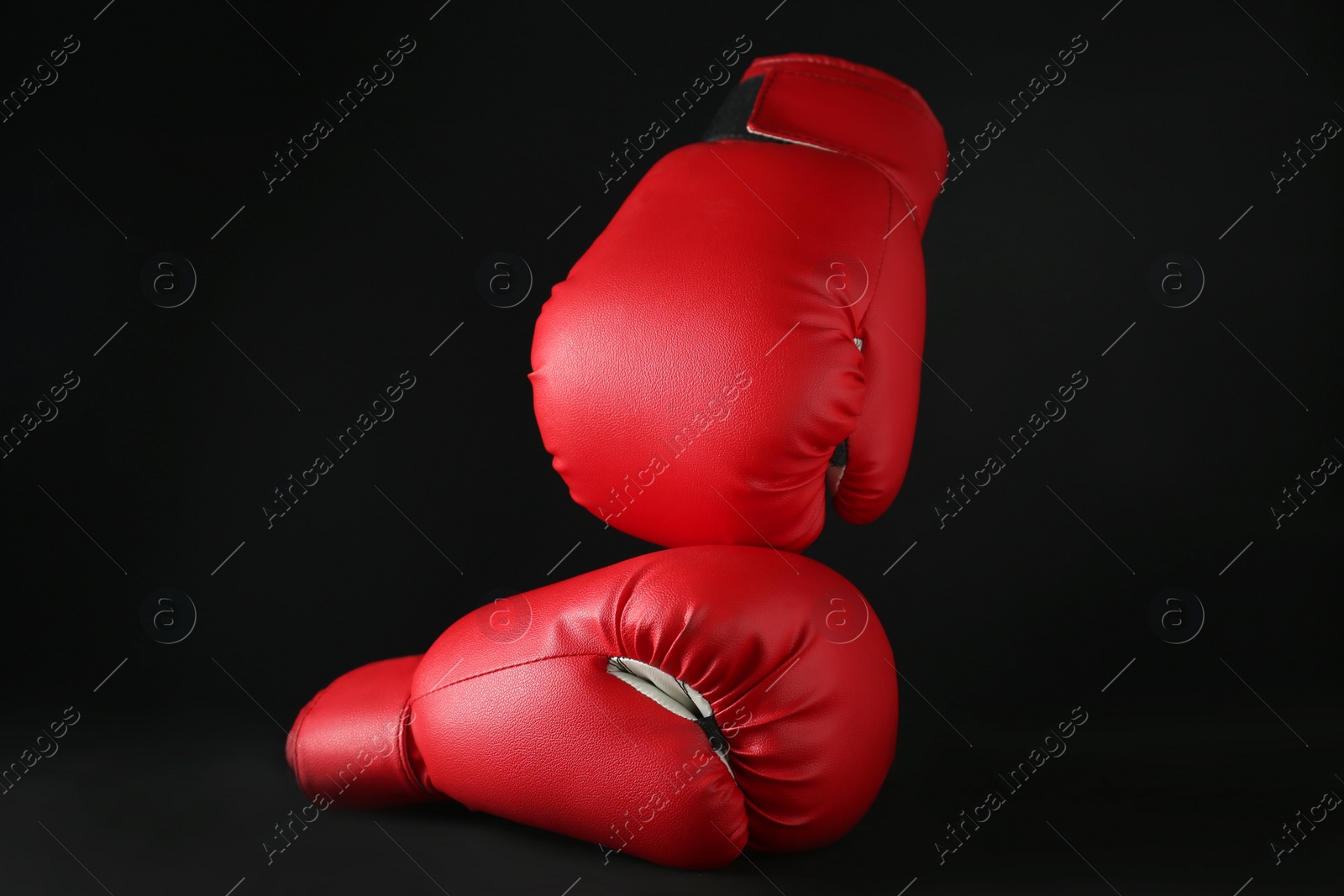 Photo of Red boxing gloves on black marble table. Competition concept