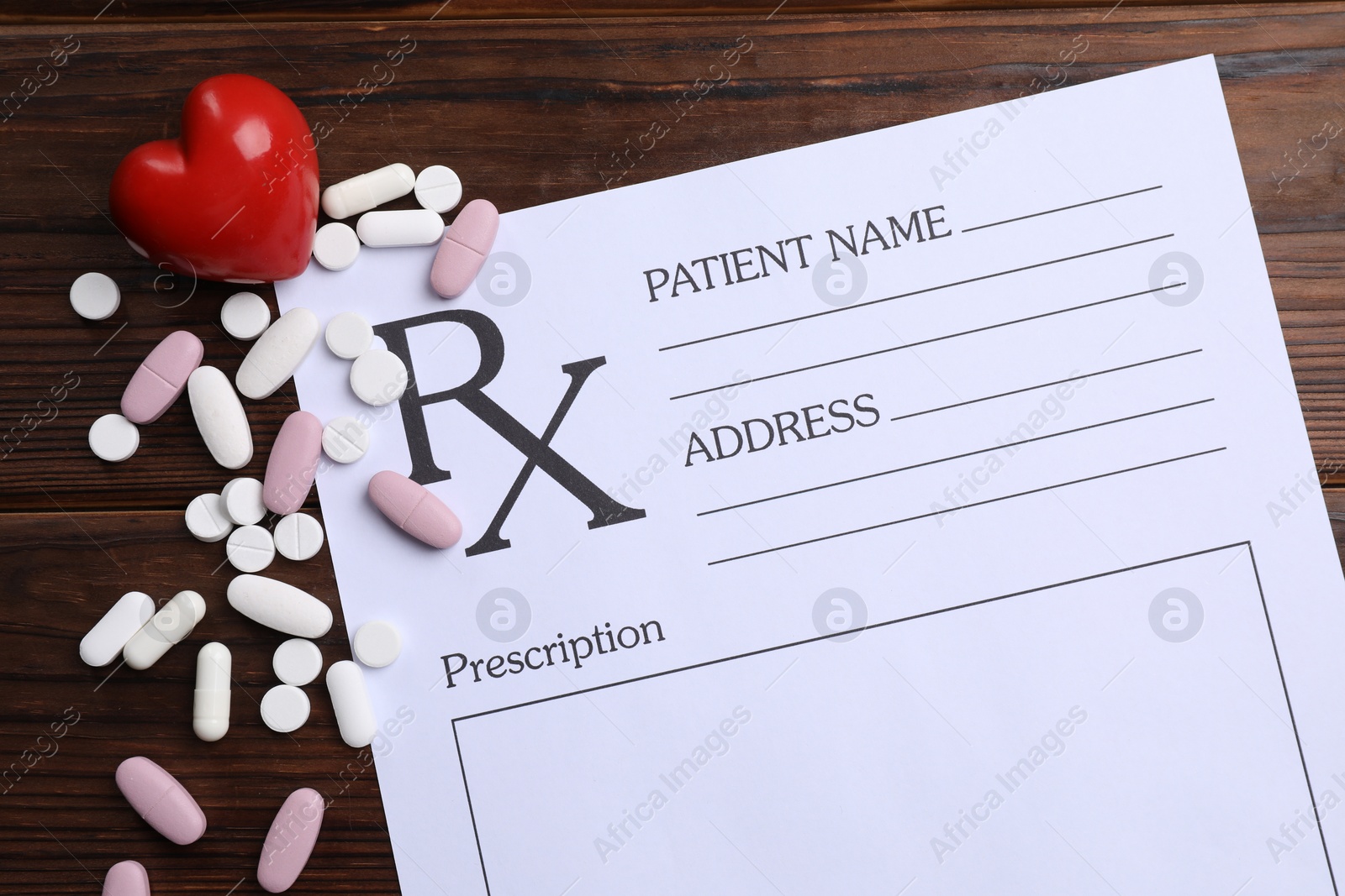 Photo of Medical prescription form with empty fields, red heart and pills on wooden table, flat lay