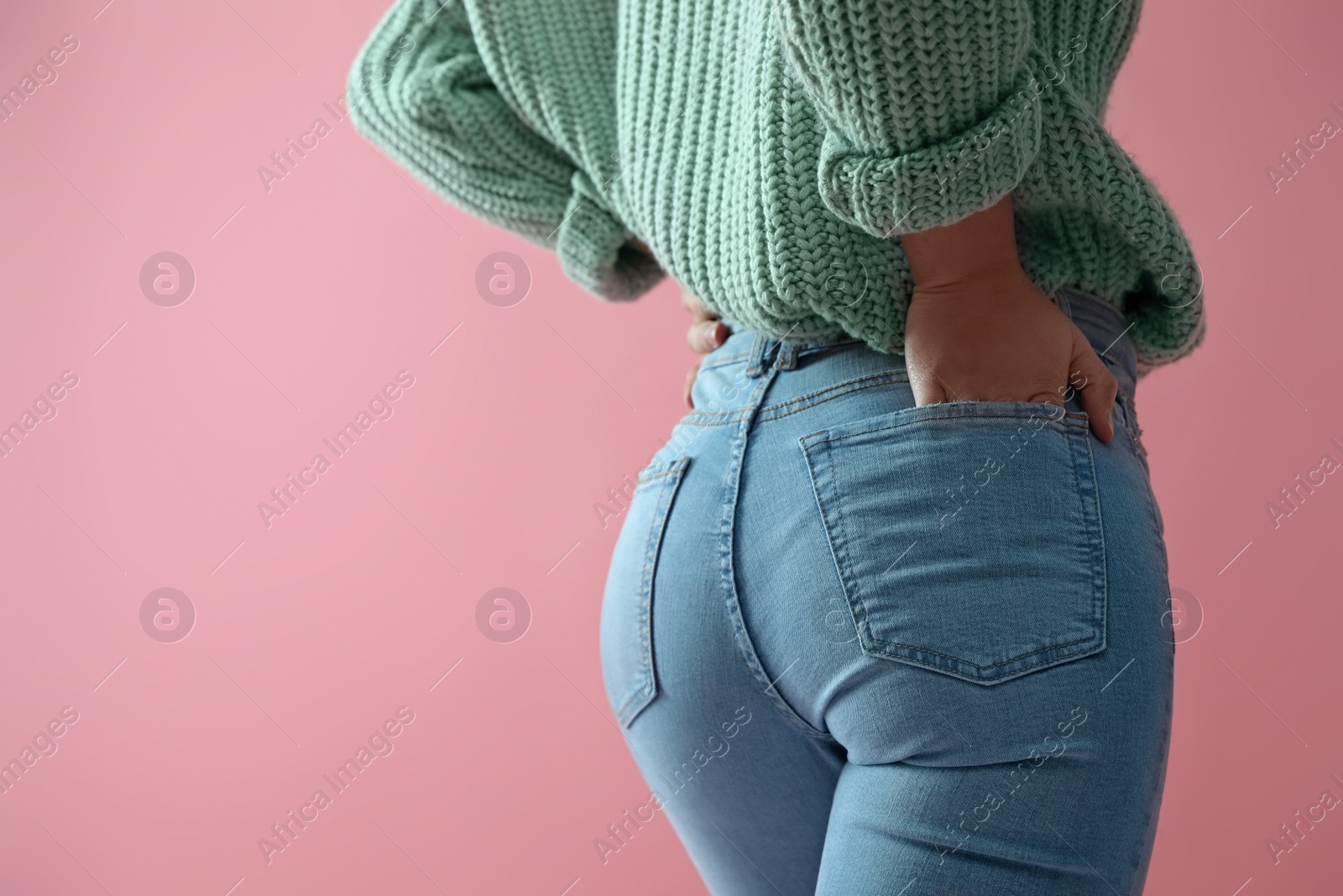 Photo of Woman wearing jeans on pink background, closeup. Space for text