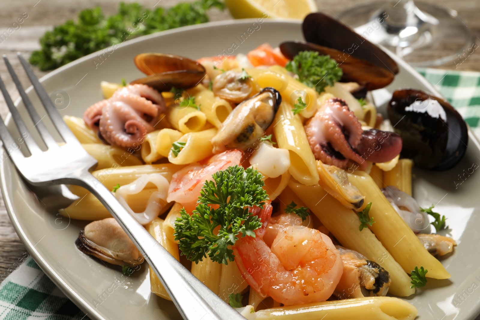 Photo of Delicious pasta with sea food served on table, closeup