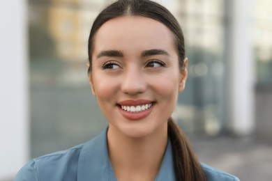 Photo of Portrait of beautiful woman on blurred background. Attractive lady smiling and posing for camera