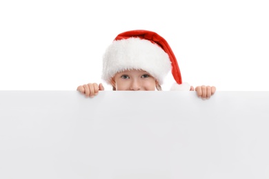 Photo of Cute little child wearing Santa hat on white background. Christmas holiday