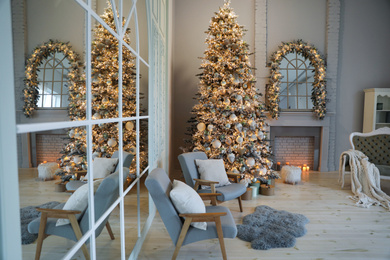 Festive room interior with stylish furniture and beautiful Christmas tree