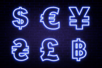 Money exchange neon sign. Blue symbols of different currencies on brick wall