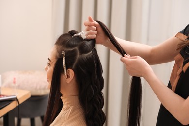 Hair styling. Professional hairdresser working with client in salon, closeup