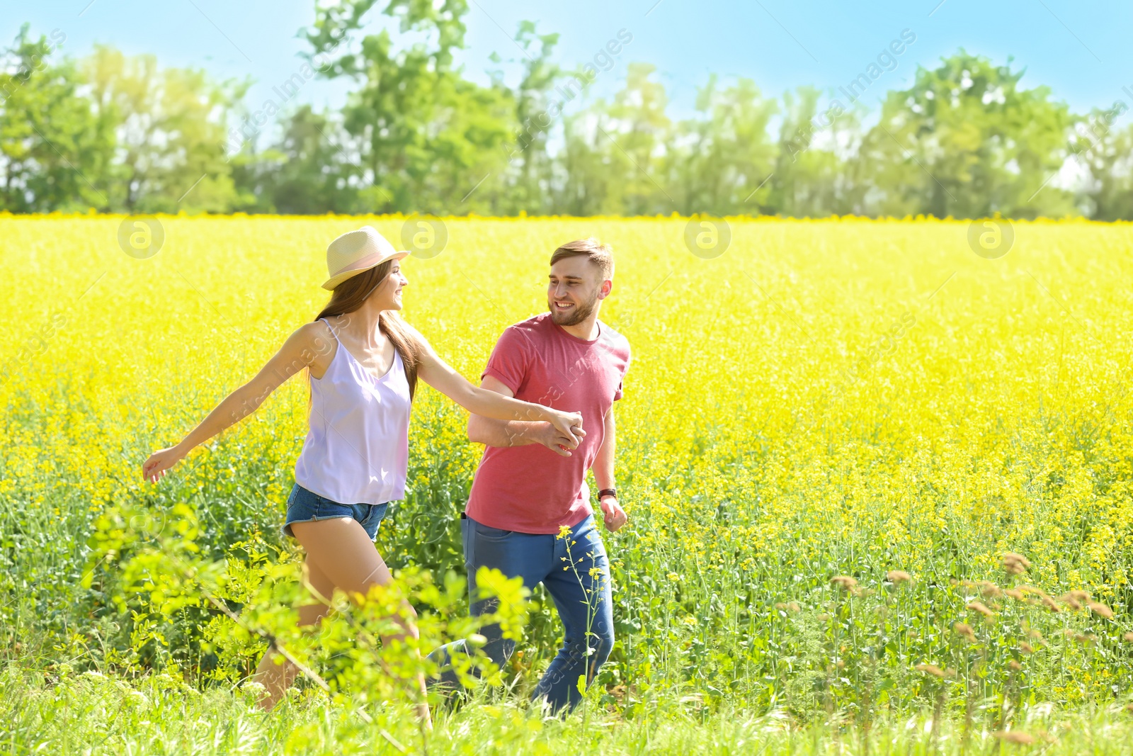 Photo of Happy young couple in green field on sunny spring day